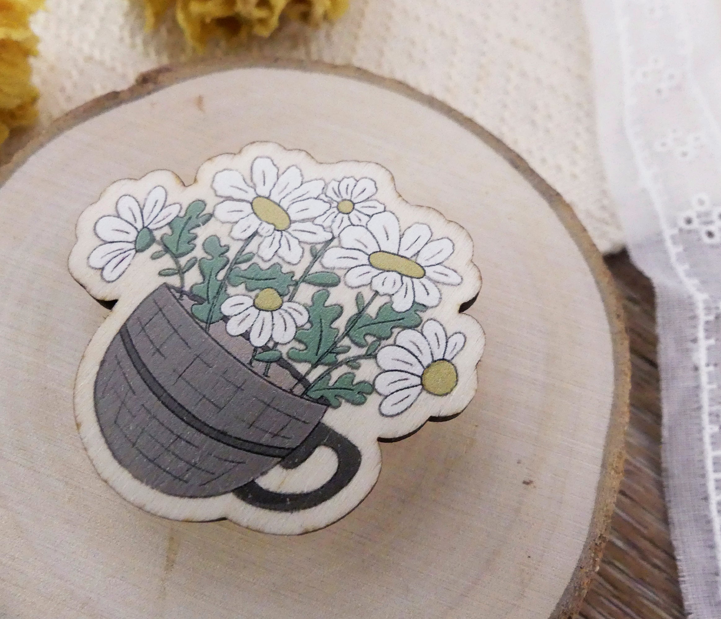 close up of a cup of daisies wooden pin